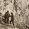 Steinbruch Kolbenstein, zwei Arbeiter mit einem Bohrhammer in der Wand. 1913