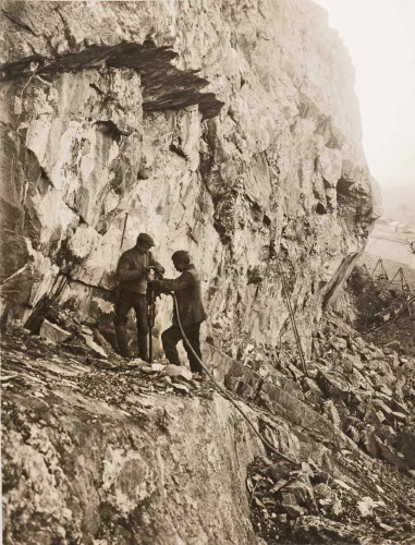 Steinbruch Kolbenstein, zwei Arbeiter mit einem Bohrhammer in der Wand. 1913