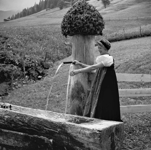 Frau in Walsertracht am Brunnen